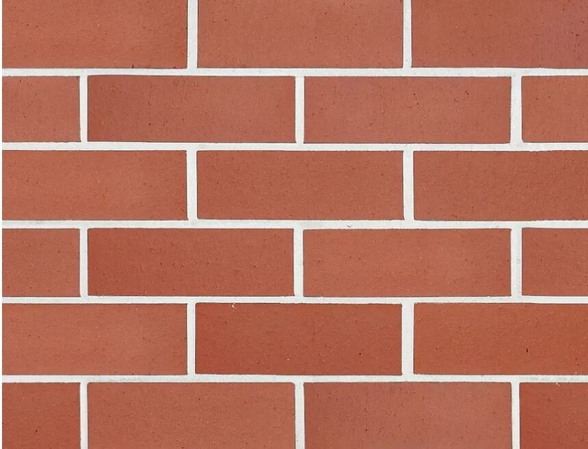 The Symmetry Terracotta bricks create a neatly arranged wall with four horizontal rows. Each brick is uniformly sized and separated by white mortar lines, resulting in a consistent pattern and perfect symmetry across the surface.