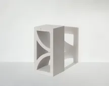 A single GB Breeze Blocks Arc Pottery in light gray with geometric cutouts stands upright on a white surface, casting a distinct shadow against the plain white background.