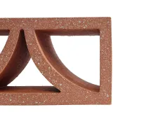 A close-up of the GB Breeze Blocks Arc Pottery brick in red, featuring geometric cutout shapes like triangles and curves, set against a white background.