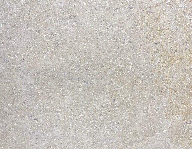 A close-up view of the Sinai Pearl S/blasted & Tumbled Paver highlights its light beige texture with subtle speckles, showcasing the unique character of a sandblasted and tumbled finish.