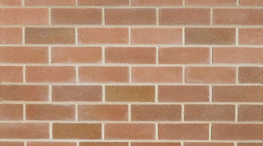 A close-up view of the Lincoln Ashfield Grey brick wall, featuring evenly spaced horizontal and vertical mortar lines that form a classic pattern reminiscent of historic architecture. The surface exhibits a slightly textured appearance with variations in grey tones.