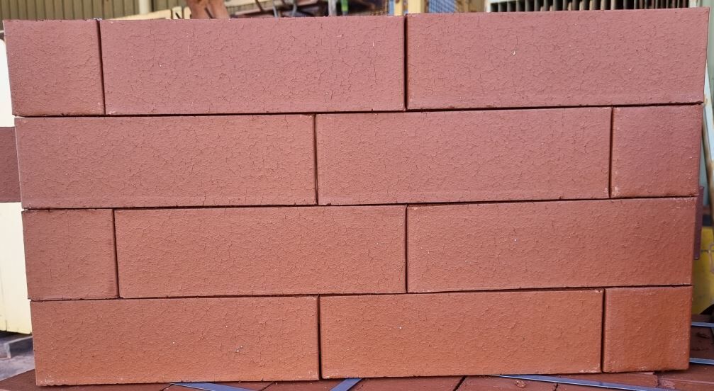 Close-up of a wall made of Modular Red Smooth bricks arranged in a staggered pattern.